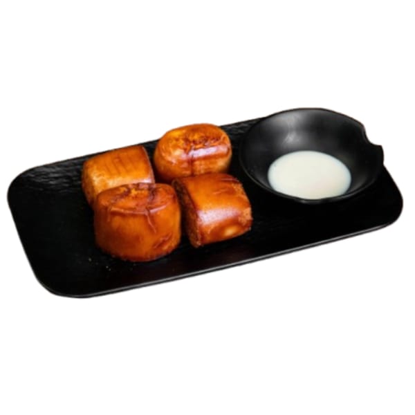 Four golden-brown fried mantou buns with a small black bowl of condensed milk on a black plate.