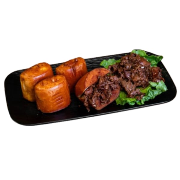 Vietnamese dish with three golden-brown buns and a portion of dark, savory meat on lettuce.